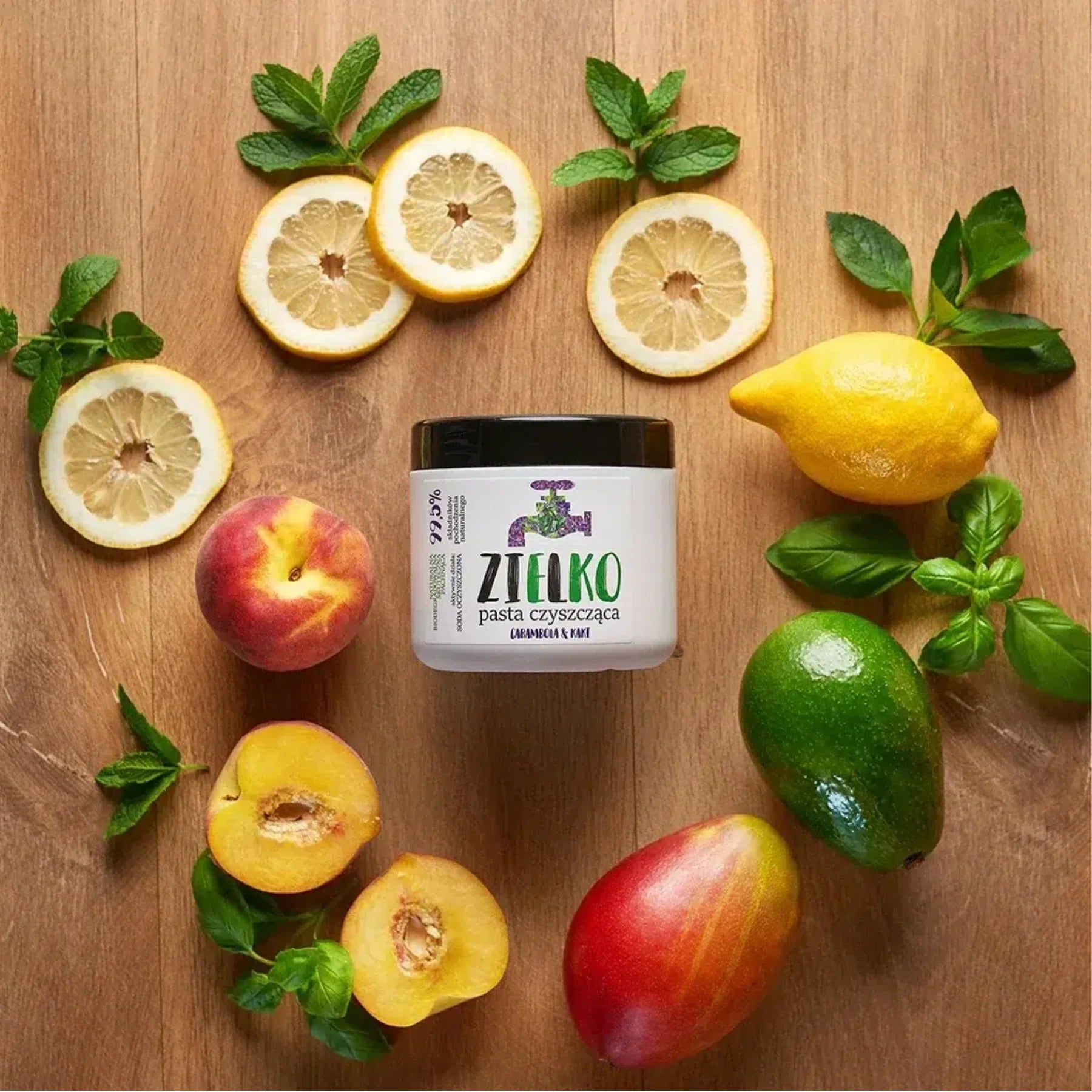 ZIELKO reinigingspasta omringd door natuurlijke vruchten – mango, citroen, perzik en munt.